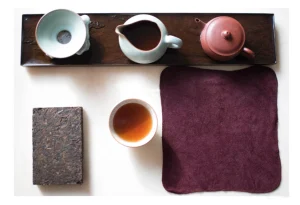 Focus on the dry tea table, the tea sets are placed in order, and a square cake of raw Pu'er is placed next to it