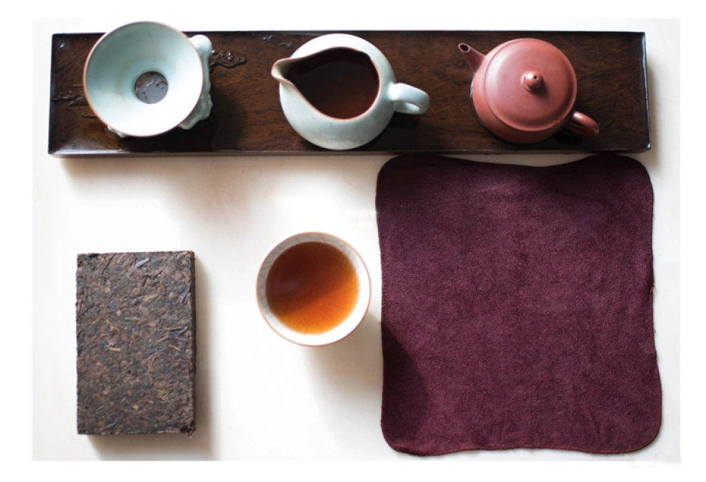 Focus on the dry tea table, the tea sets are placed in order, and a square cake of raw Pu'er is placed next to it