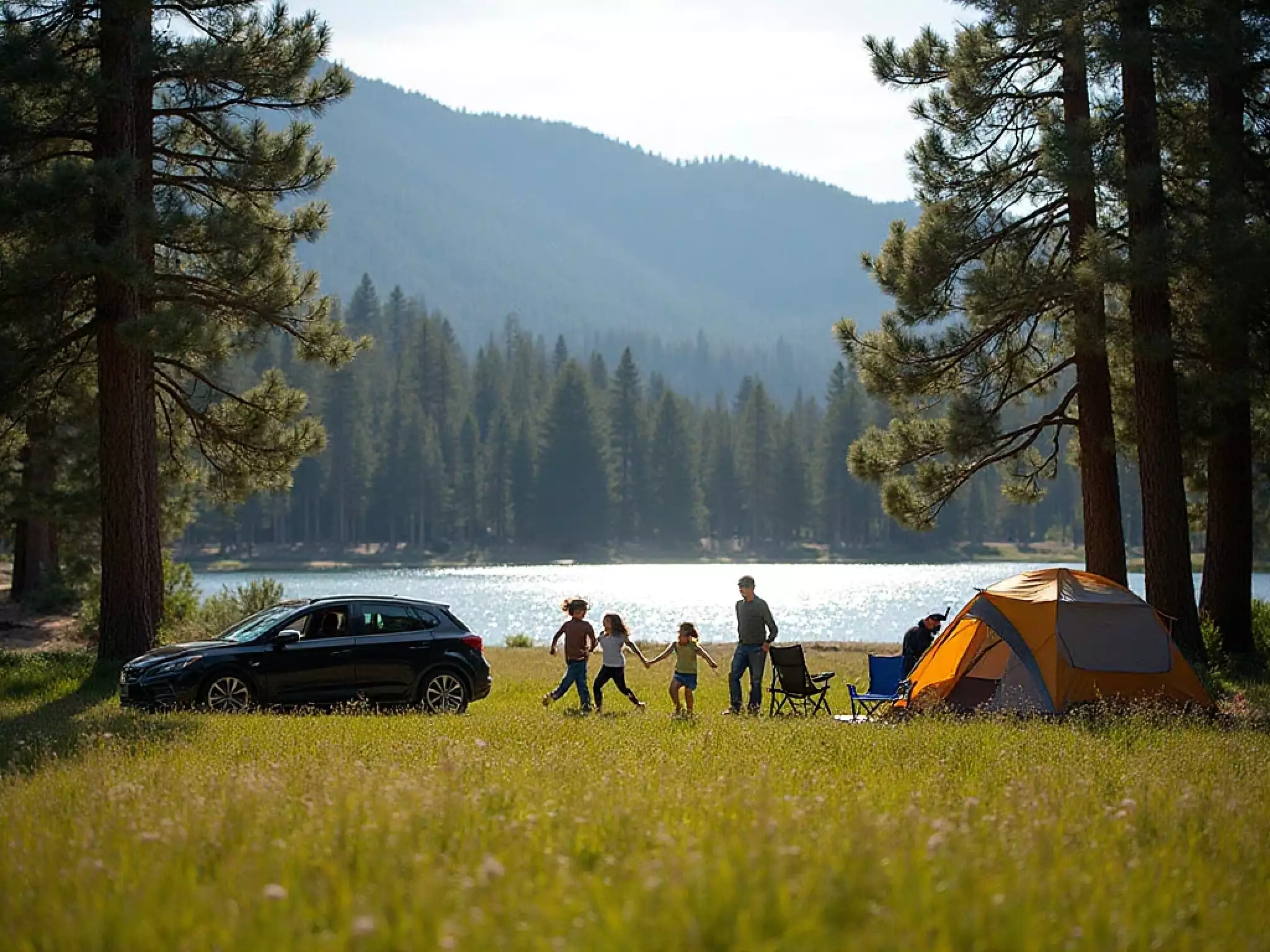 Family setting up camp by Big Bear Lake with mountains in the background