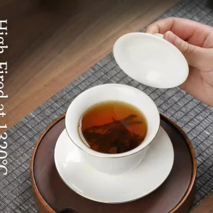 Professional white porcelain Gaiwan high-fired at 1320°C held in hand for Kung Fu tea brewing