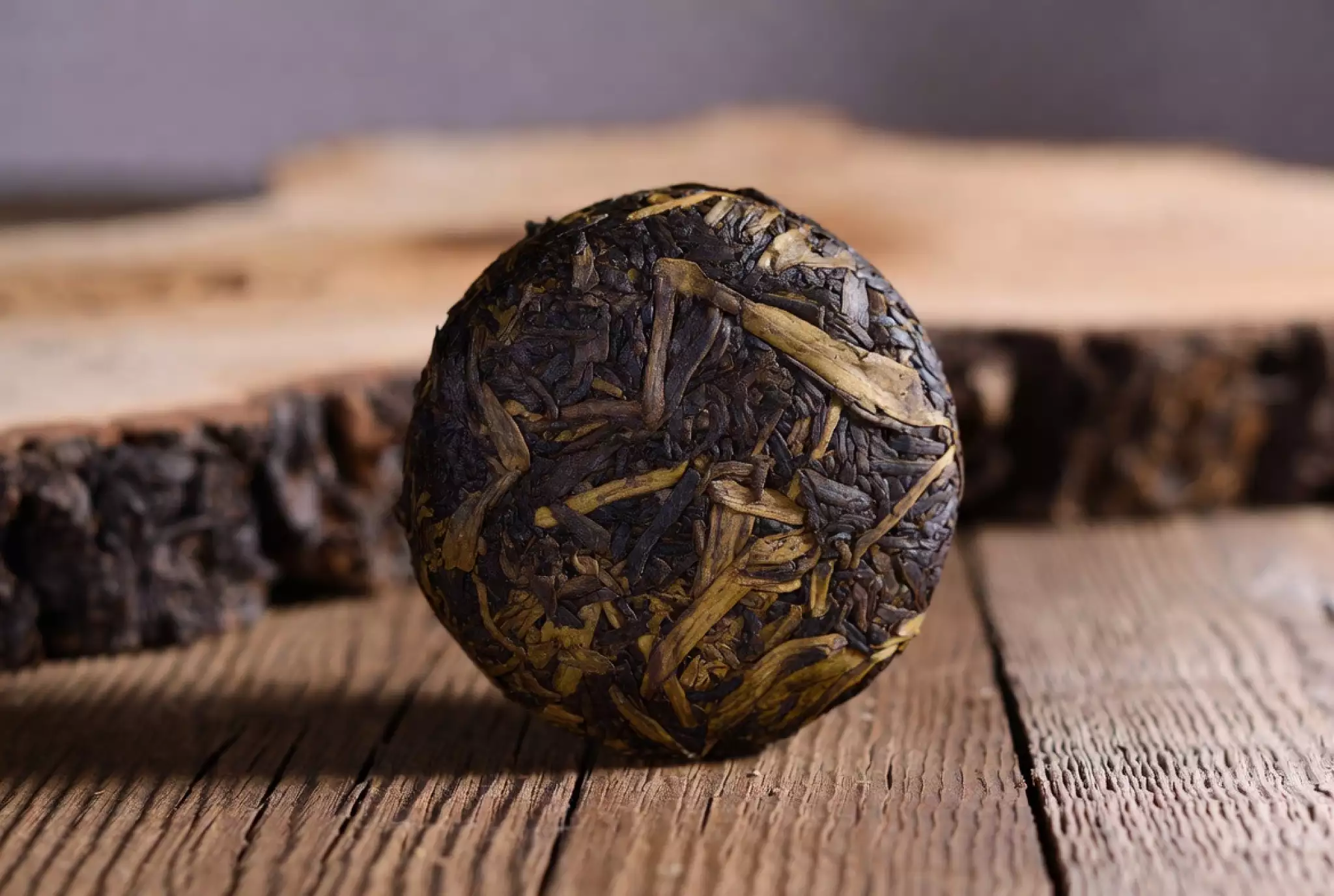 Yunnan large-leaf tea sample or 2g portion, showing twisted leaves or compressed form with rich texture