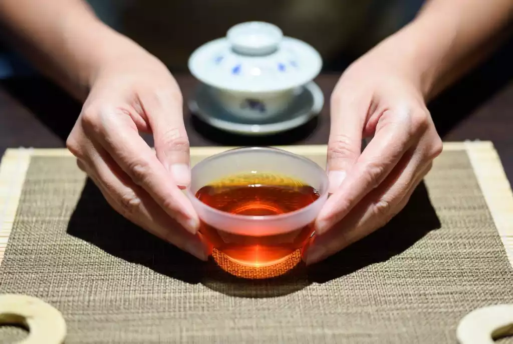 A peaceful close-up of amber-red Chinese tea in a glass cup, symbolizing the mindful tea ritual