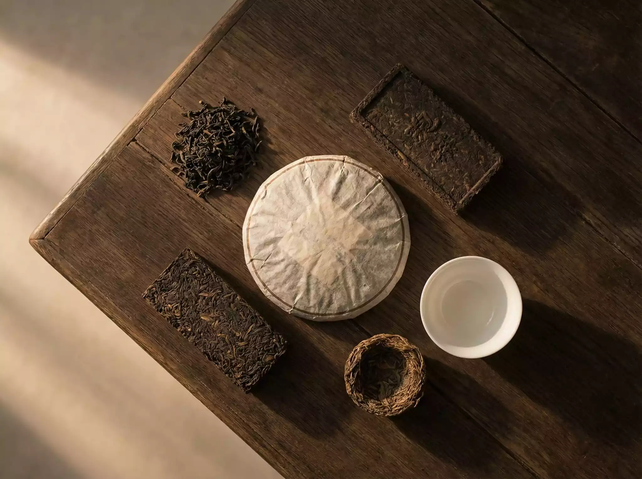 Minimalist flat lay of various Pu-erh tea shapes and compressions