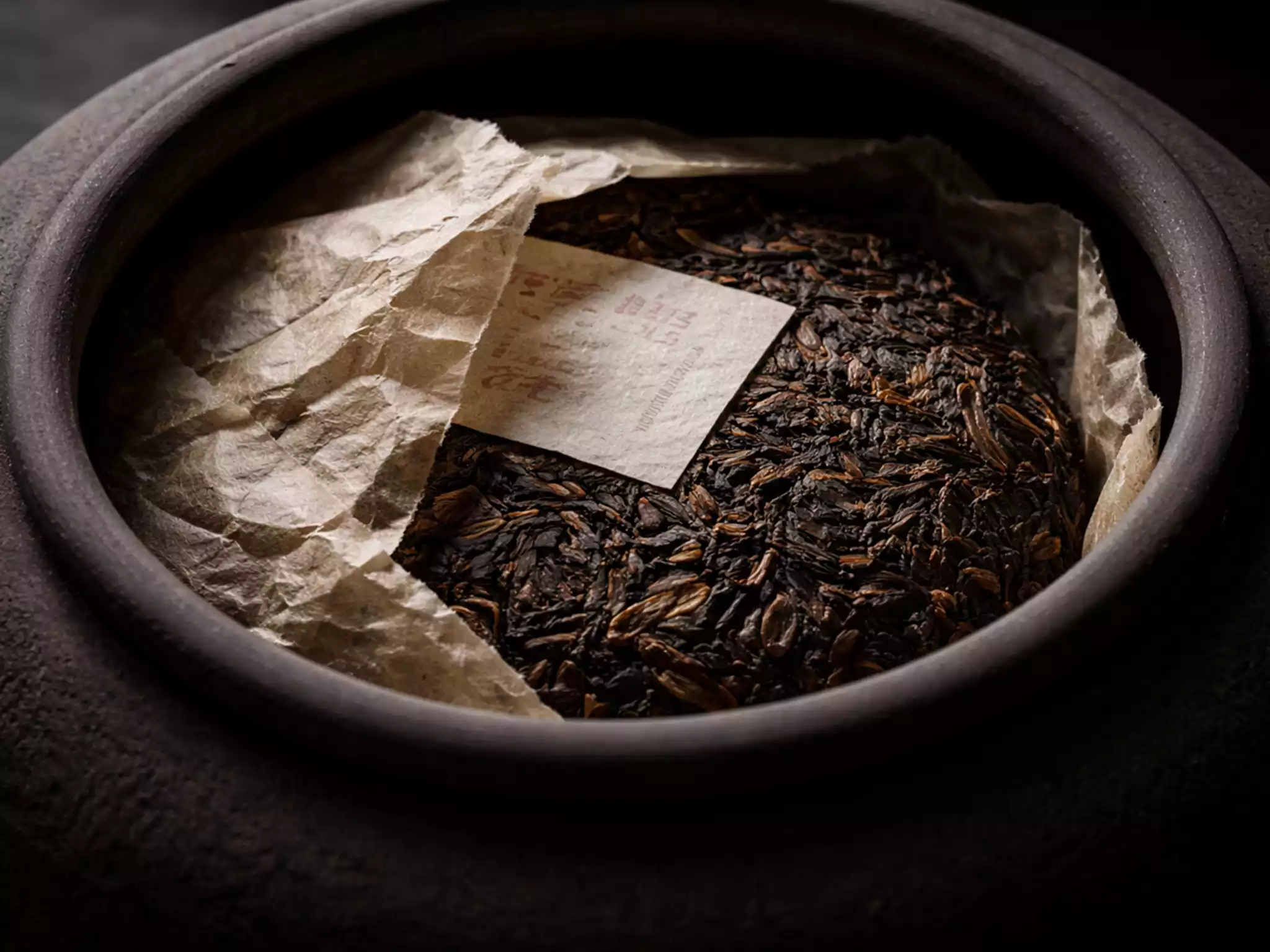 Aged raw Pu-erh tea cake in handmade stone-pressed paper for microbial fermentation